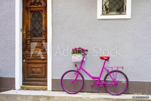 Bild på pink bike standing by the wall